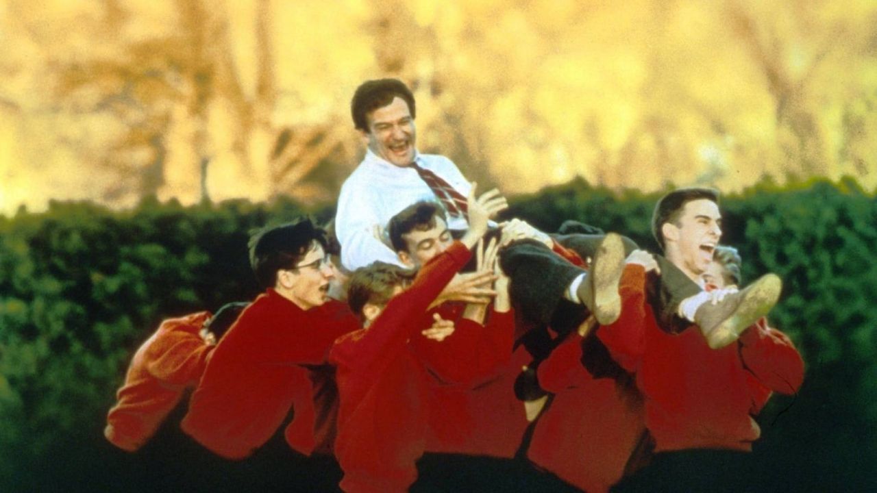 Robin Williams portato in trionfo dai suoi studenti in una scena di L'attimo Fuggente, fonte Warner Bros. Italia