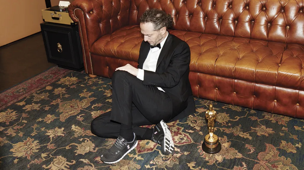 Emmanuel Chivo Lubezki seduto sul tappeto con l'Oscar