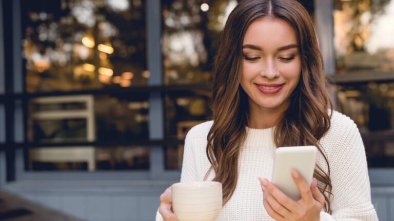 Ragazza felice guarda il suo smartphone