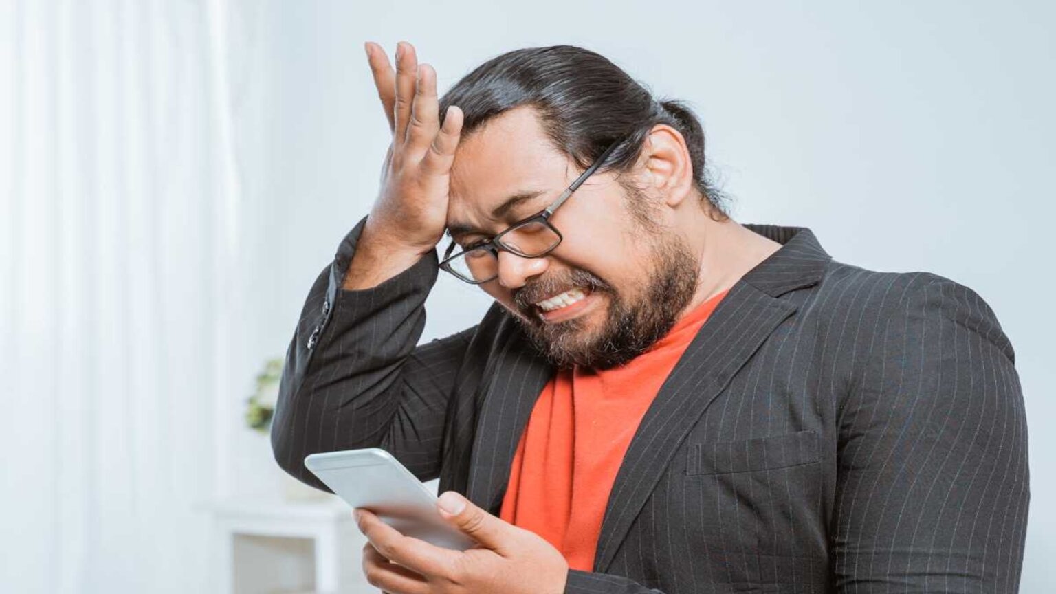 La nuova truffa via mail sembra arrivare da Microsoft: basta un codice per perdere tutto Un uomo con uno smartphone