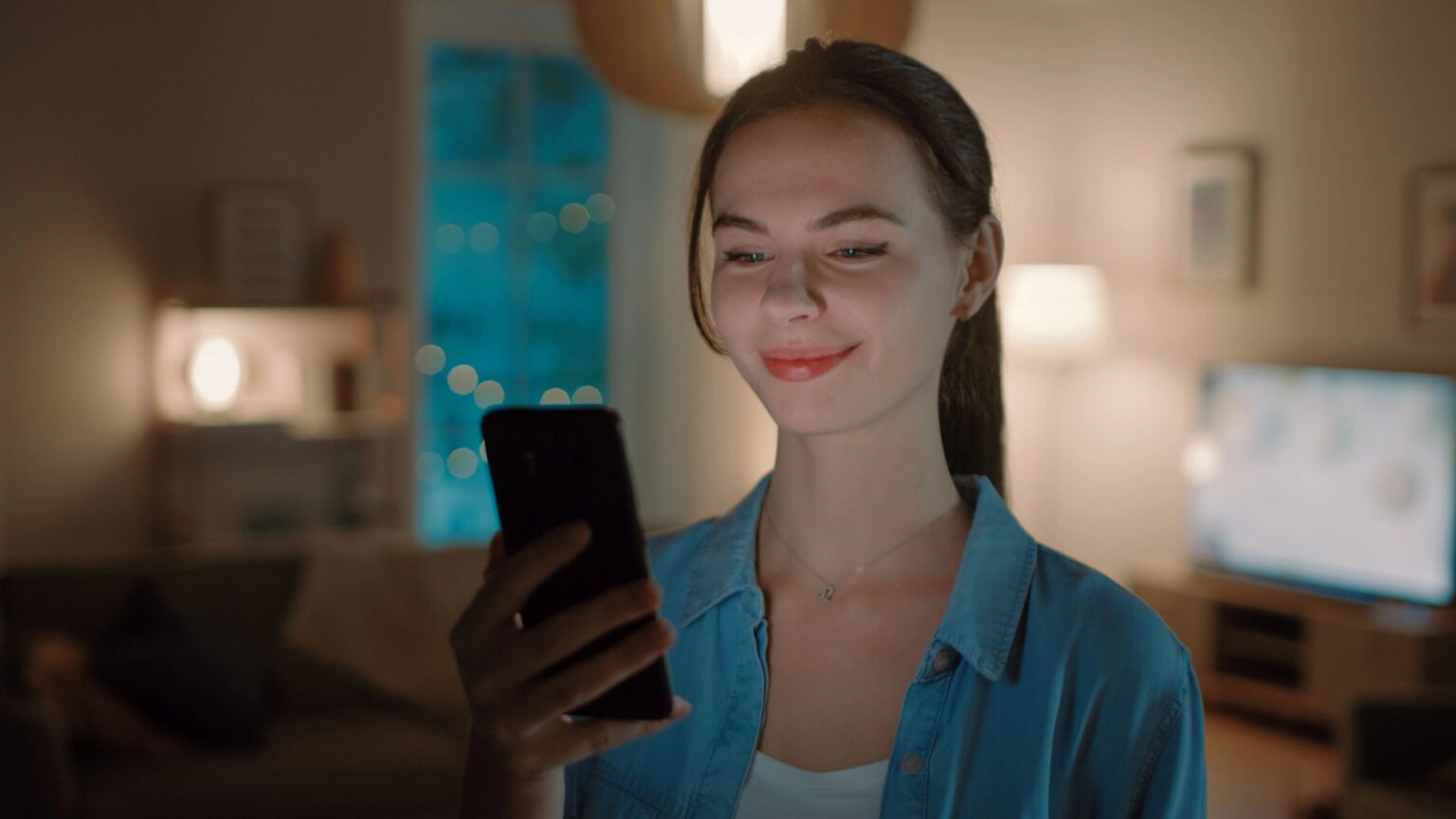 WhatsApp rivoluziona i vocali: il trucco nascosto che ora è disponibile su Android Ragazza guarda il suo smartphone felice